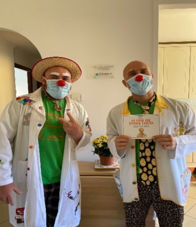 Due medici con camice, mascherina e naso da clown