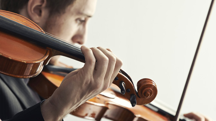 Dettaglio di una fotografia a due violinisti indica il supporto di BNL BNP Paribas al mondo della musica e dello spettacolo. 