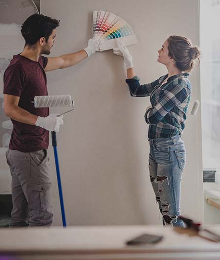 giovane coppia di uomo e donna che scelgono il colore per tinteggiare le pareti di casa