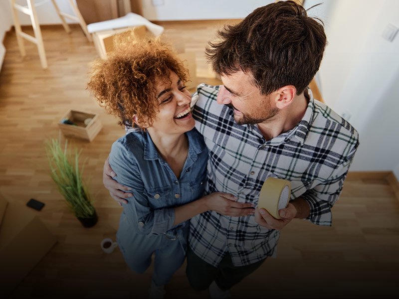 Mutui BNL: un uomo e una donna ridono abbracciati tra gli scatoloni del trasloco