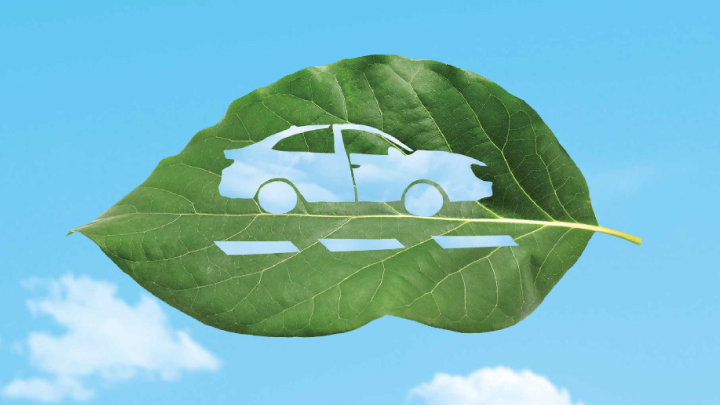 Elaborazione grafica dell'immagine di un'automobile  ricavata intagliando una foglia verde su sfondo di un ciele con nuvole