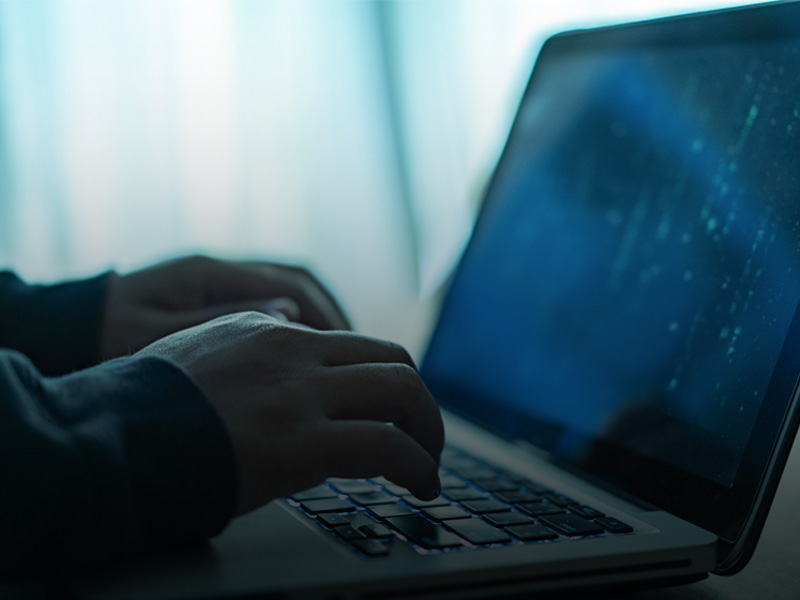 Immagine fotografica di due mani che digitano sulla tastiera di un computer portatile
