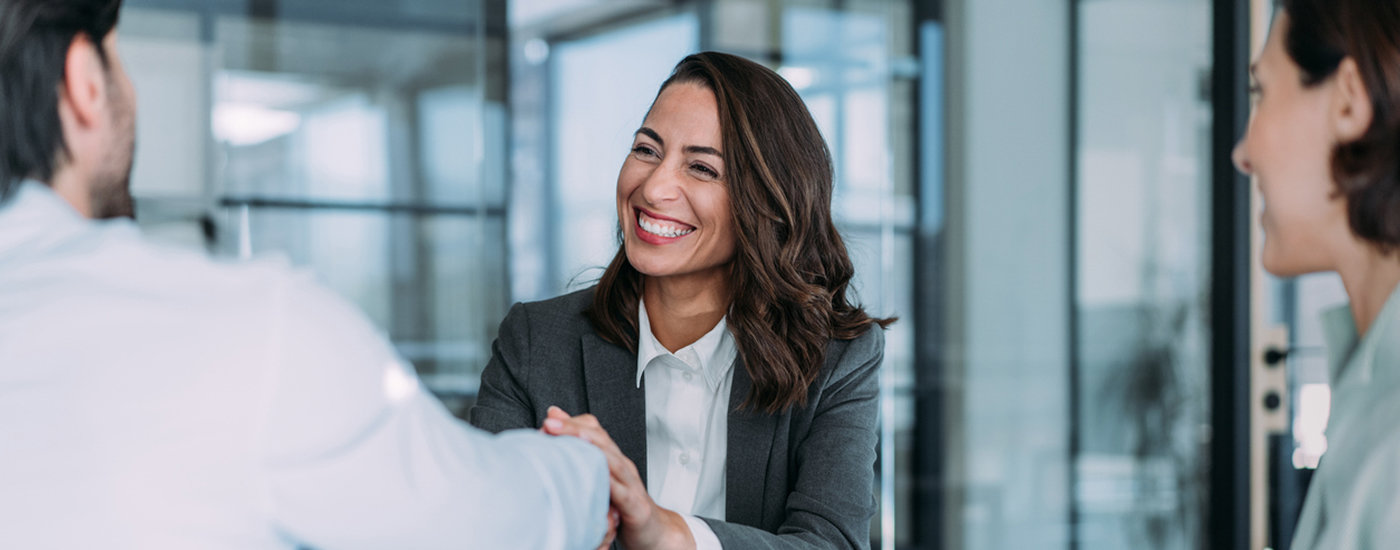 Consulente sorridente stringe la mano a un cliente durante un incontro in filiale