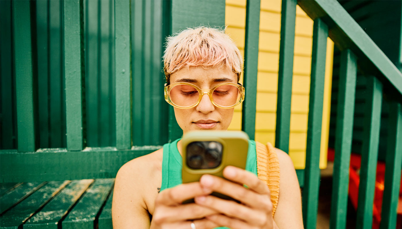 Ragazza che usa il suo smartphone in un contesto di vacanza