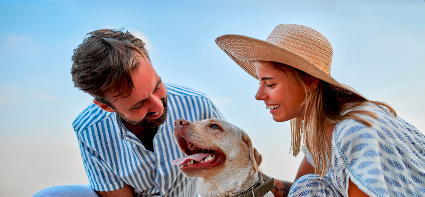 coppia sorridente all'aperto con un cane