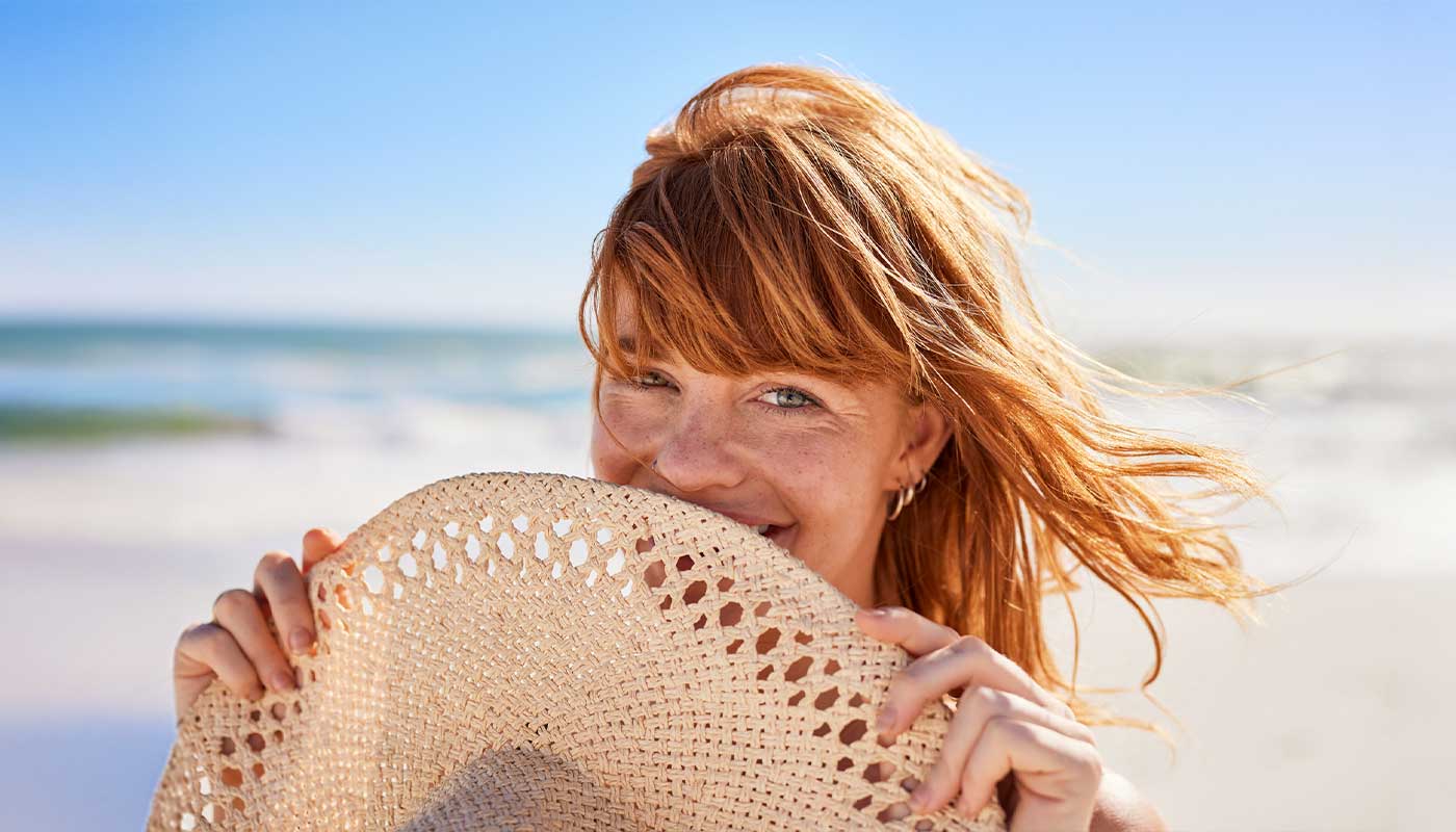 donna al mare con cappello paglia