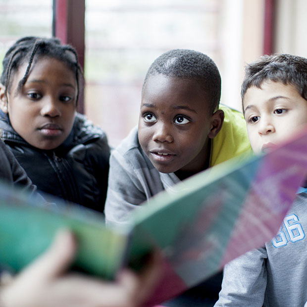 Tre bambini che ascoltano una fiaba indicano sul sito BNL BNP Paribas le attività di Fondazione BNL a sostegno dell'infanzia.