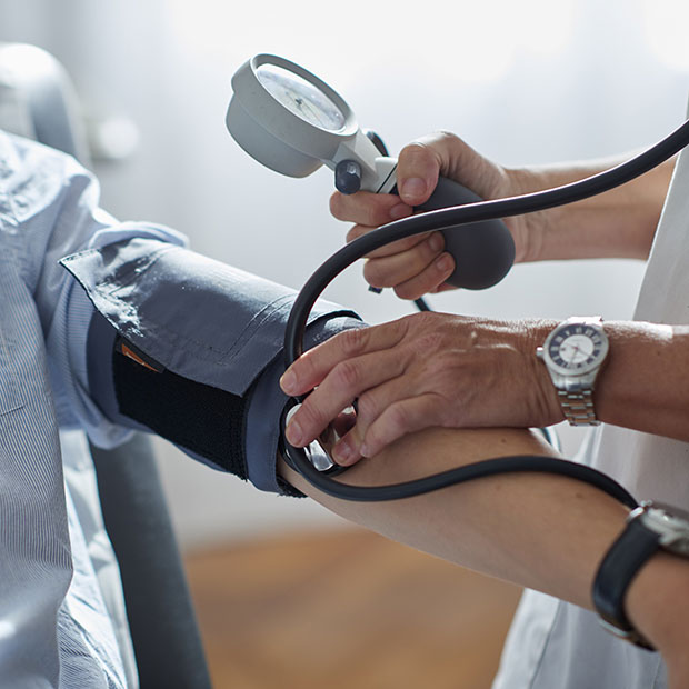 Un medico che misura la pressione ad un paziente indica le attività di Fondazione BNL a supporto del settore sanitario.