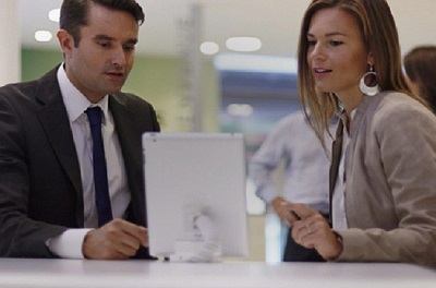 Un uomo e una donna lavorano insieme con un tablet in uno spazio di lavoro all'interno di una moderna e innovativa sede BNL.