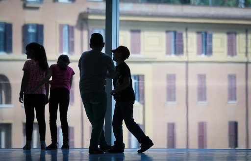 Quattro bambini davanti a una vetrata a Fondazione MAXXI in partnership con BNL.